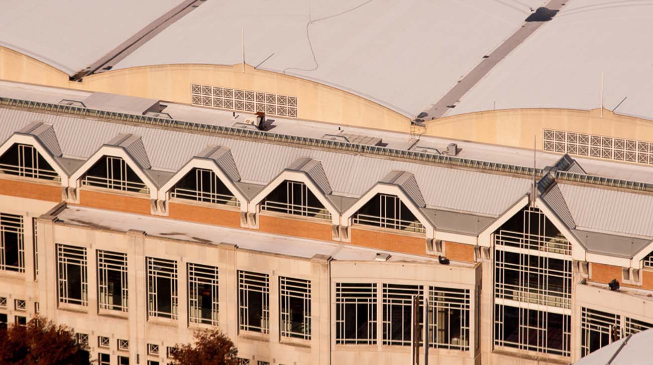 A close-up view of a modern building's facade featuring geometric windows and a curved roof structure.